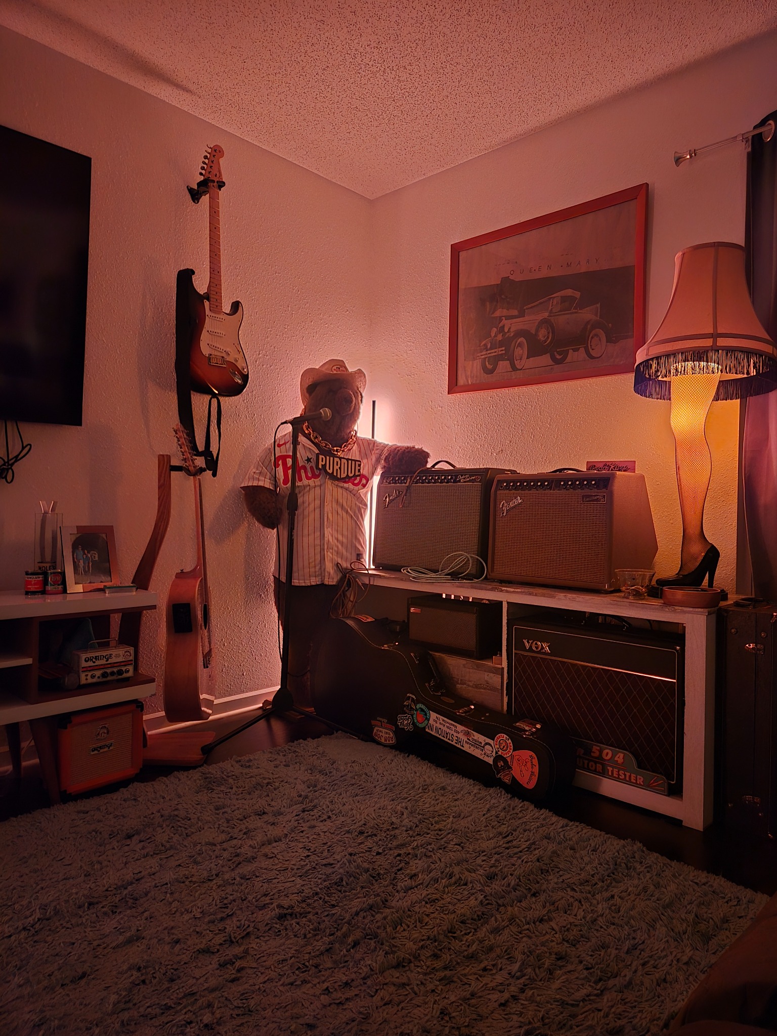 Rosie, a large bear in a Purdue jersey, standing at a microphone among guitars and amplifiers in Seth’s home studio